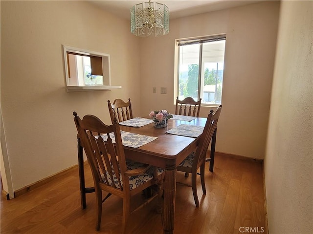 dining room with wood-type flooring and a notable chandelier