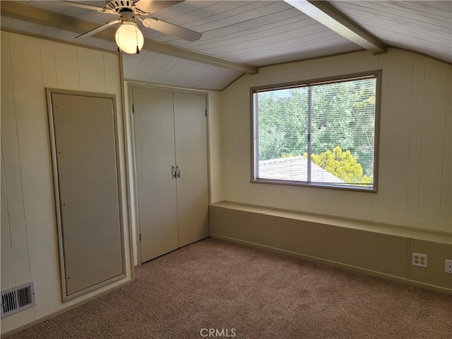 unfurnished bedroom featuring light colored carpet, lofted ceiling with beams, a closet, and ceiling fan