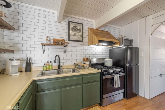 kitchen featuring stainless steel appliances, green cabinetry, light hardwood / wood-style floors, and sink