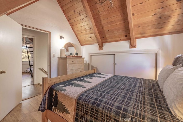 bedroom with lofted ceiling with beams, light hardwood / wood-style floors, a closet, and wood ceiling