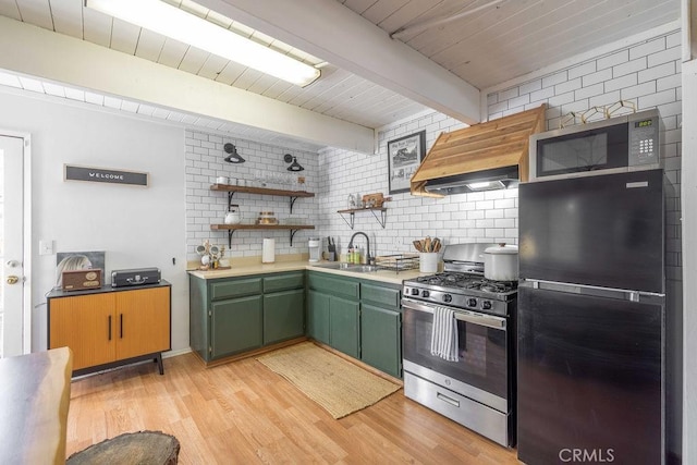 kitchen with appliances with stainless steel finishes, light wood-type flooring, custom range hood, sink, and green cabinetry