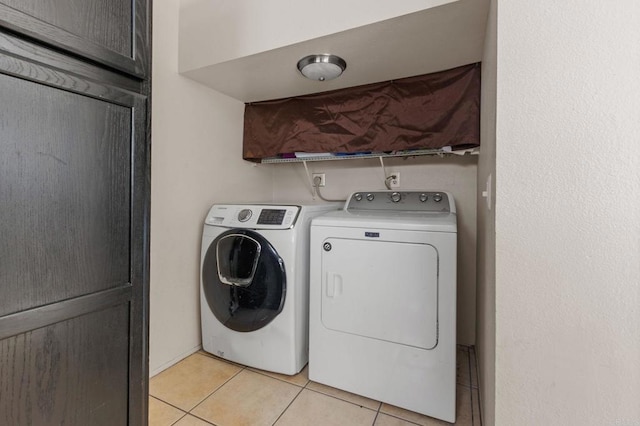 laundry area with light tile patterned floors, cabinets, and washer and dryer