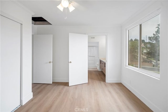 unfurnished bedroom featuring ceiling fan, crown molding, ensuite bathroom, and light hardwood / wood-style flooring