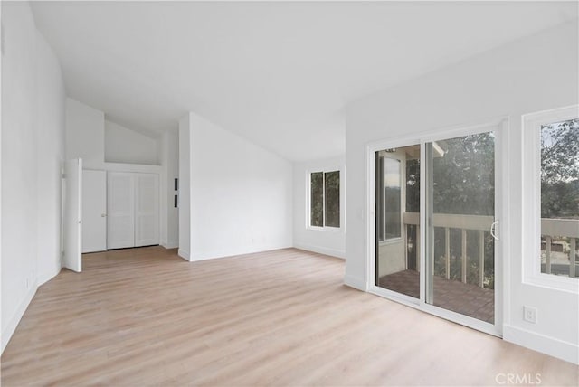 empty room with lofted ceiling and light wood-type flooring