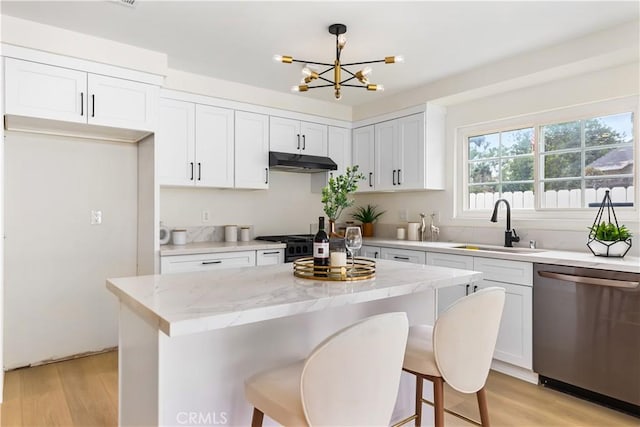 kitchen with dishwasher, a center island, sink, decorative light fixtures, and white cabinetry