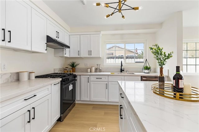 kitchen with high end range, an inviting chandelier, white cabinets, sink, and light hardwood / wood-style flooring