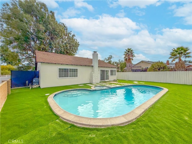 view of swimming pool with a yard