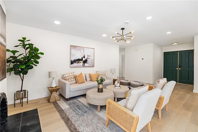 living room with light hardwood / wood-style flooring and a notable chandelier