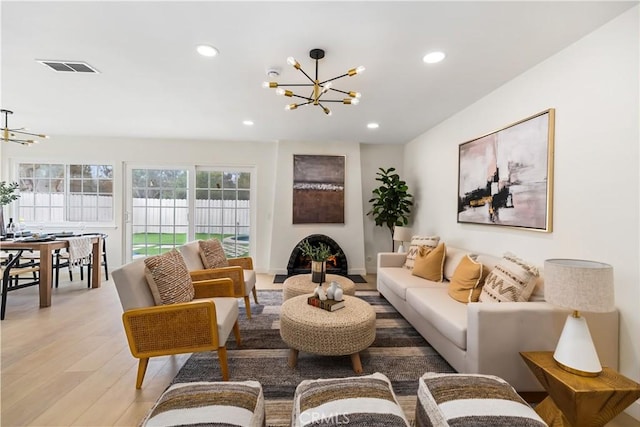 living room with light wood-type flooring and a notable chandelier