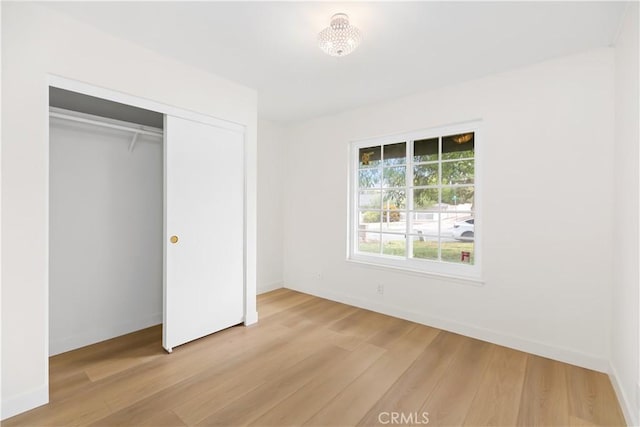 unfurnished bedroom featuring a closet and light wood-type flooring