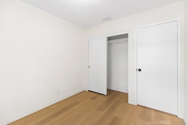 unfurnished bedroom featuring light hardwood / wood-style floors and a closet