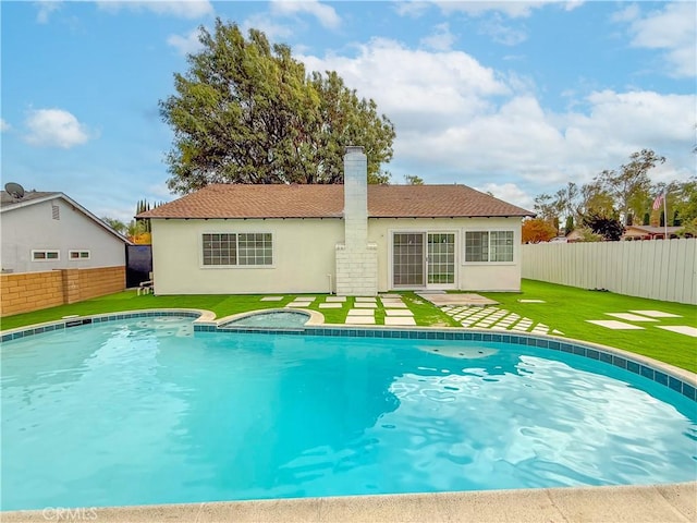 view of swimming pool featuring an in ground hot tub and a lawn