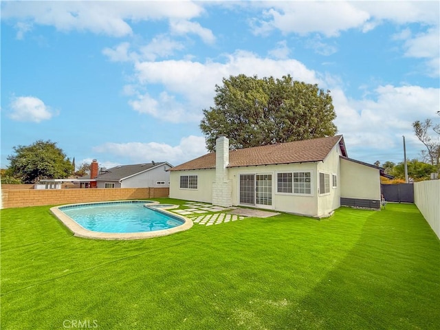 back of property featuring a fenced in pool and a yard