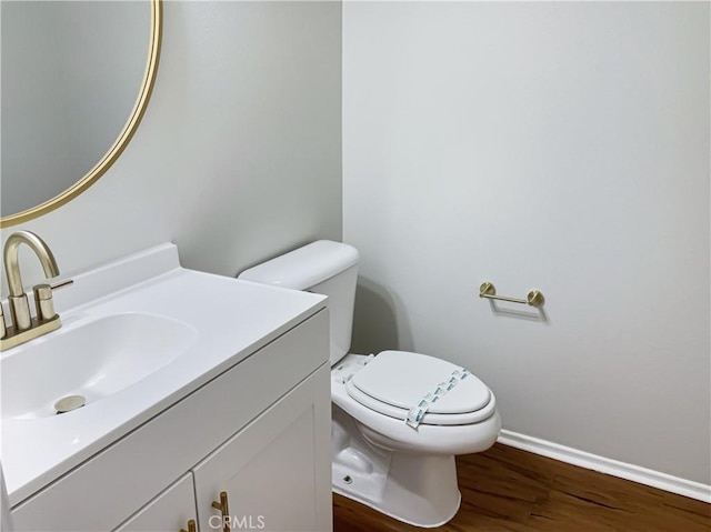 bathroom with toilet, vanity, and hardwood / wood-style flooring