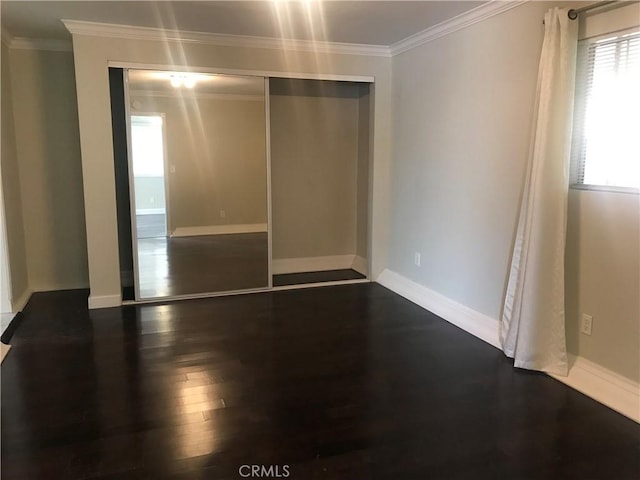 spare room featuring ornamental molding and dark wood-type flooring