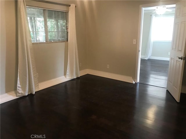 spare room with ceiling fan and dark hardwood / wood-style flooring