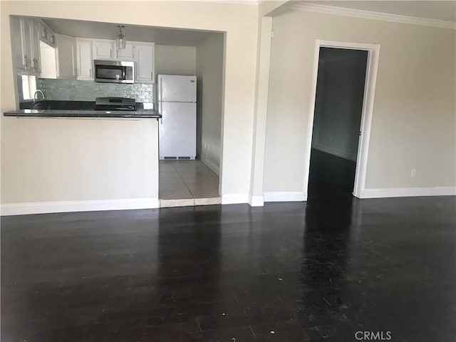 kitchen with tasteful backsplash, hardwood / wood-style floors, white fridge, white cabinets, and range