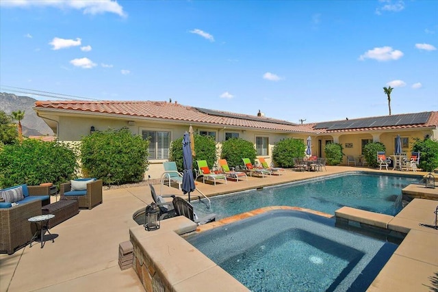 view of pool featuring outdoor lounge area, an in ground hot tub, pool water feature, and a patio