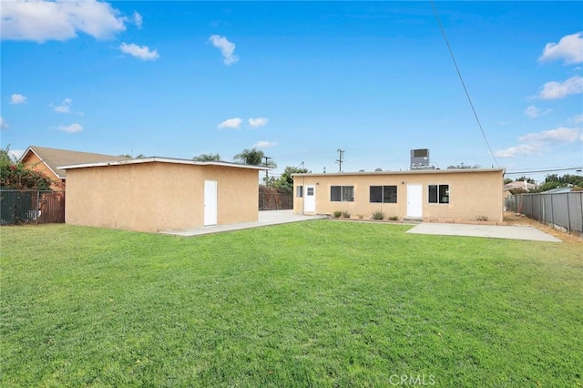 back of house featuring a lawn and a patio