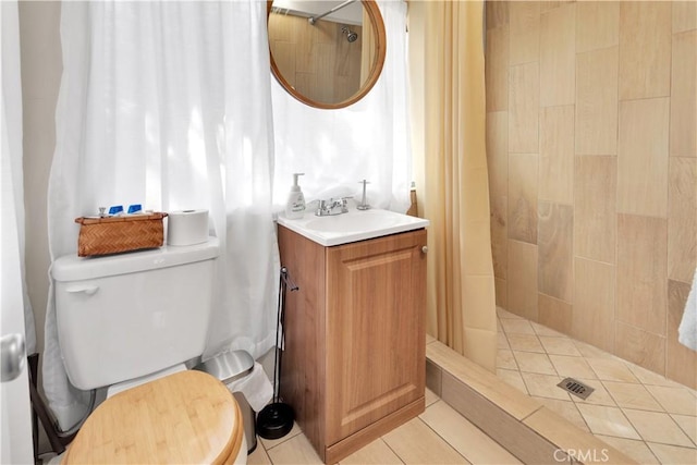 bathroom with a shower with curtain, vanity, toilet, and tile patterned floors