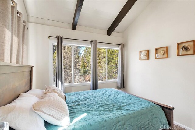 bedroom with vaulted ceiling with beams