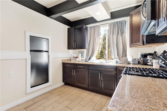 kitchen with beamed ceiling, dark brown cabinets, stainless steel appliances, and sink