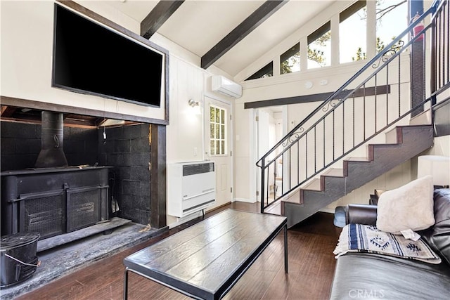 living room featuring beamed ceiling, dark hardwood / wood-style flooring, a wood stove, and heating unit