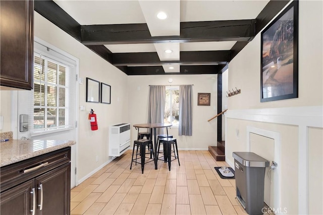 dining space with plenty of natural light, beam ceiling, light hardwood / wood-style flooring, and heating unit