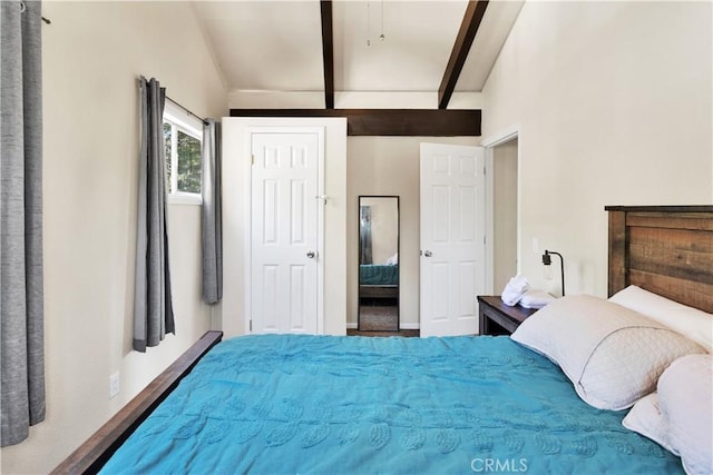 bedroom featuring wood-type flooring and vaulted ceiling with beams