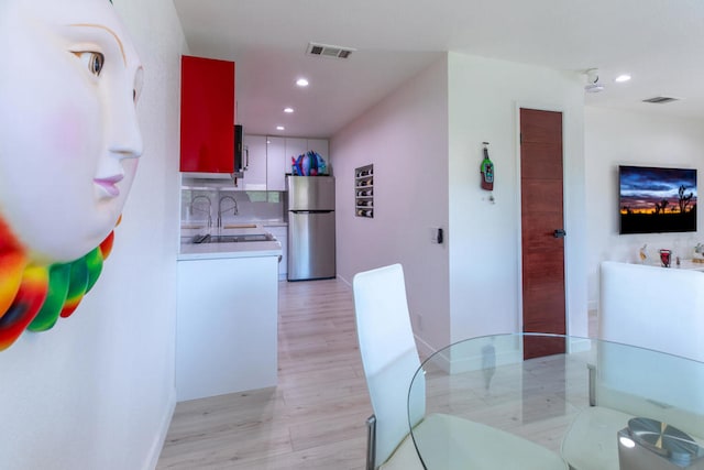 dining space featuring light hardwood / wood-style floors and sink