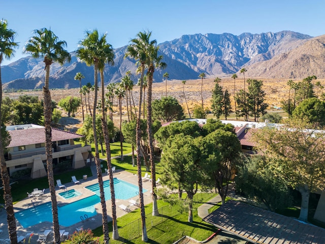 view of swimming pool with a patio area, a mountain view, and a yard