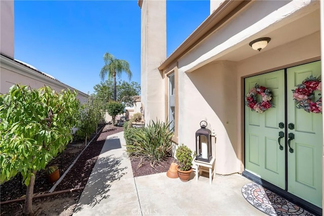 property entrance with a patio area and stucco siding