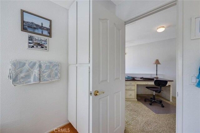 carpeted home office with built in desk