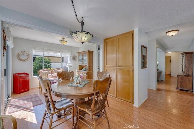 dining room featuring visible vents, light wood-style flooring, and baseboards