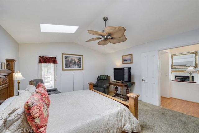 bedroom with vaulted ceiling with skylight, carpet, and a ceiling fan