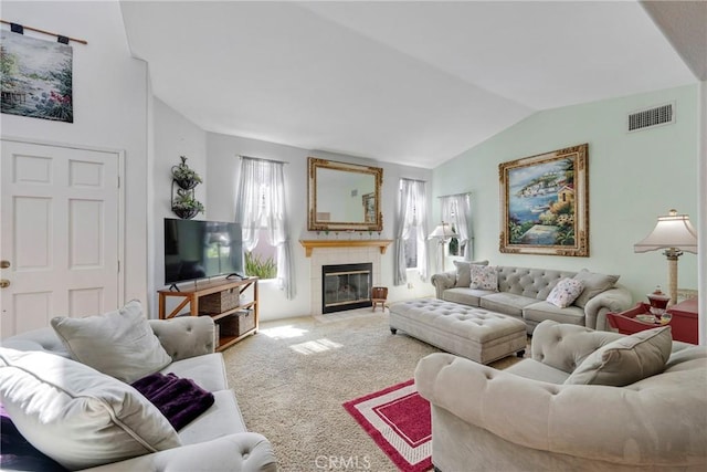 carpeted living area featuring lofted ceiling, visible vents, and a tiled fireplace