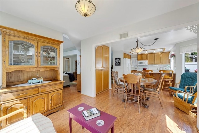 dining room featuring light wood-type flooring and visible vents