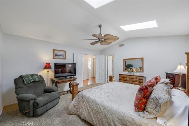 carpeted bedroom featuring ceiling fan and vaulted ceiling with skylight