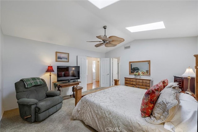 bedroom with lofted ceiling with skylight, carpet, visible vents, and a ceiling fan