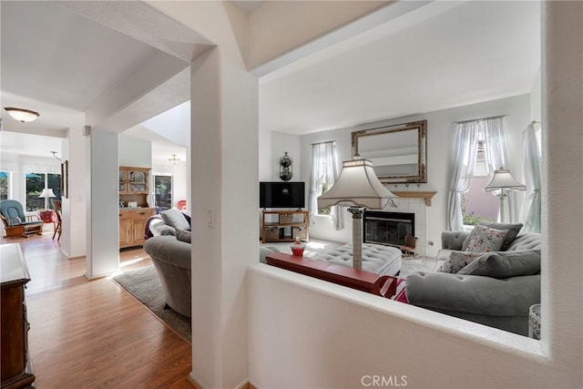 living area with a tiled fireplace and wood finished floors