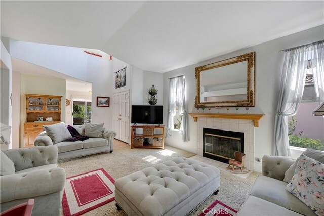 carpeted living room with lofted ceiling and a fireplace