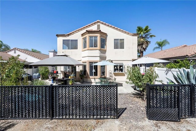 back of property featuring a gazebo and a patio area