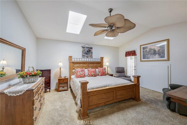 bedroom with ceiling fan, lofted ceiling with skylight, and light carpet