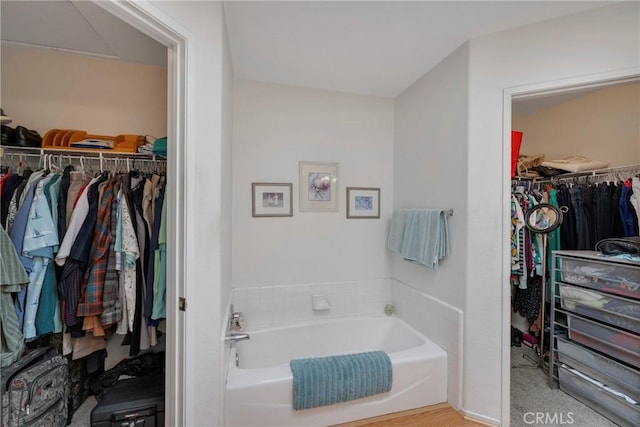 full bathroom featuring a garden tub and a walk in closet