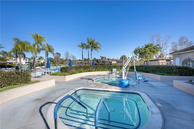 view of pool with a hot tub