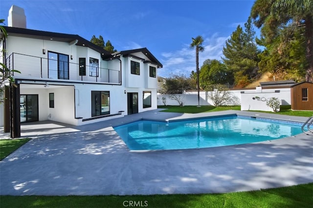 view of pool featuring a patio area and a shed