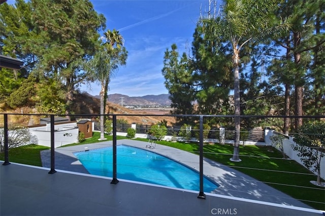 view of pool featuring a mountain view, a shed, and a yard