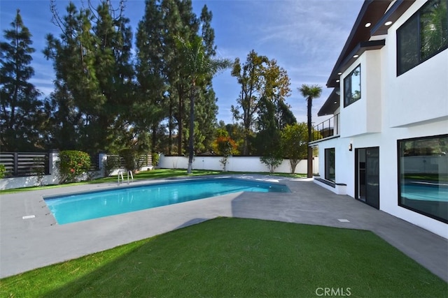 view of swimming pool with a yard and a patio