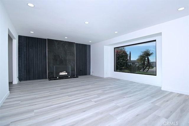 unfurnished room featuring light hardwood / wood-style floors and a fireplace