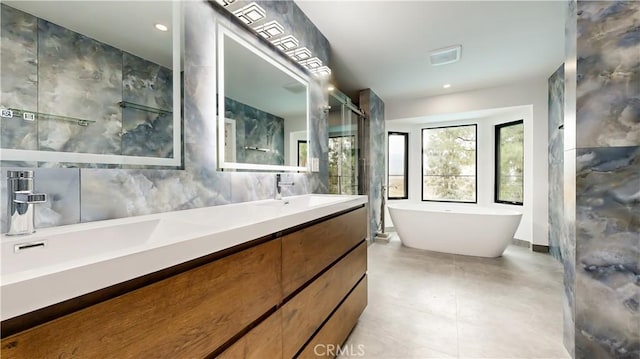 bathroom featuring a bathtub, tile walls, and vanity